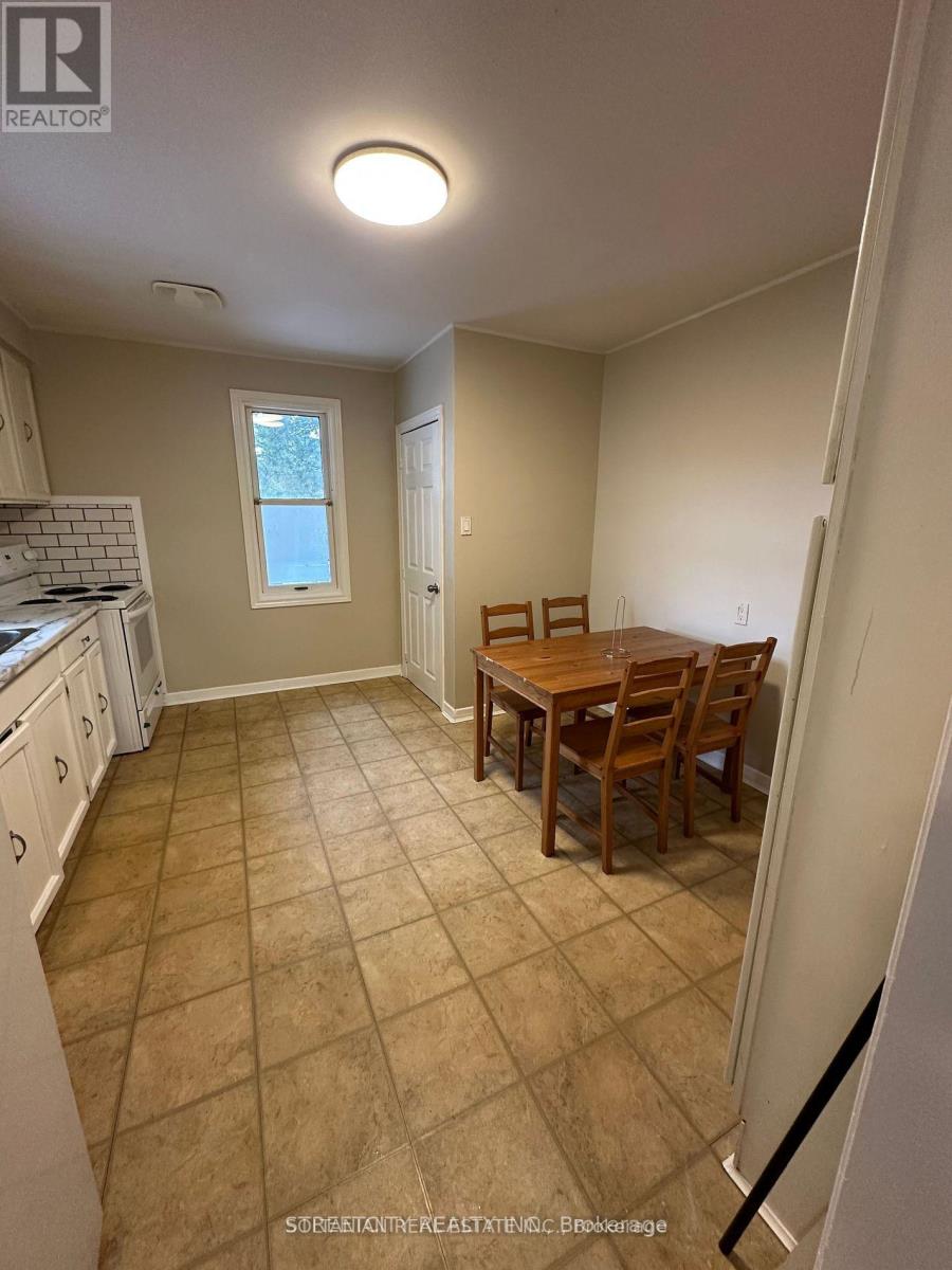 A kitchen with a dining table and chairs.