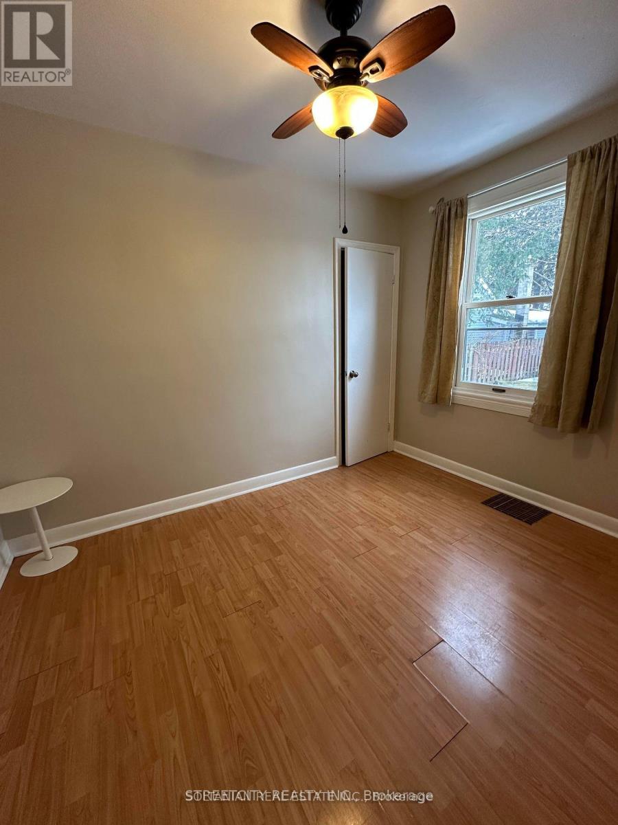 A room with a ceiling fan and wooden flooring.