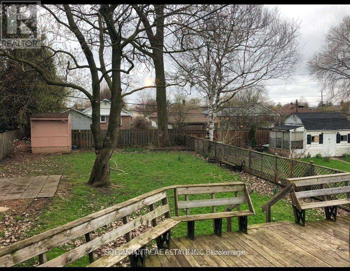 A backyard with a wooden deck and benches.