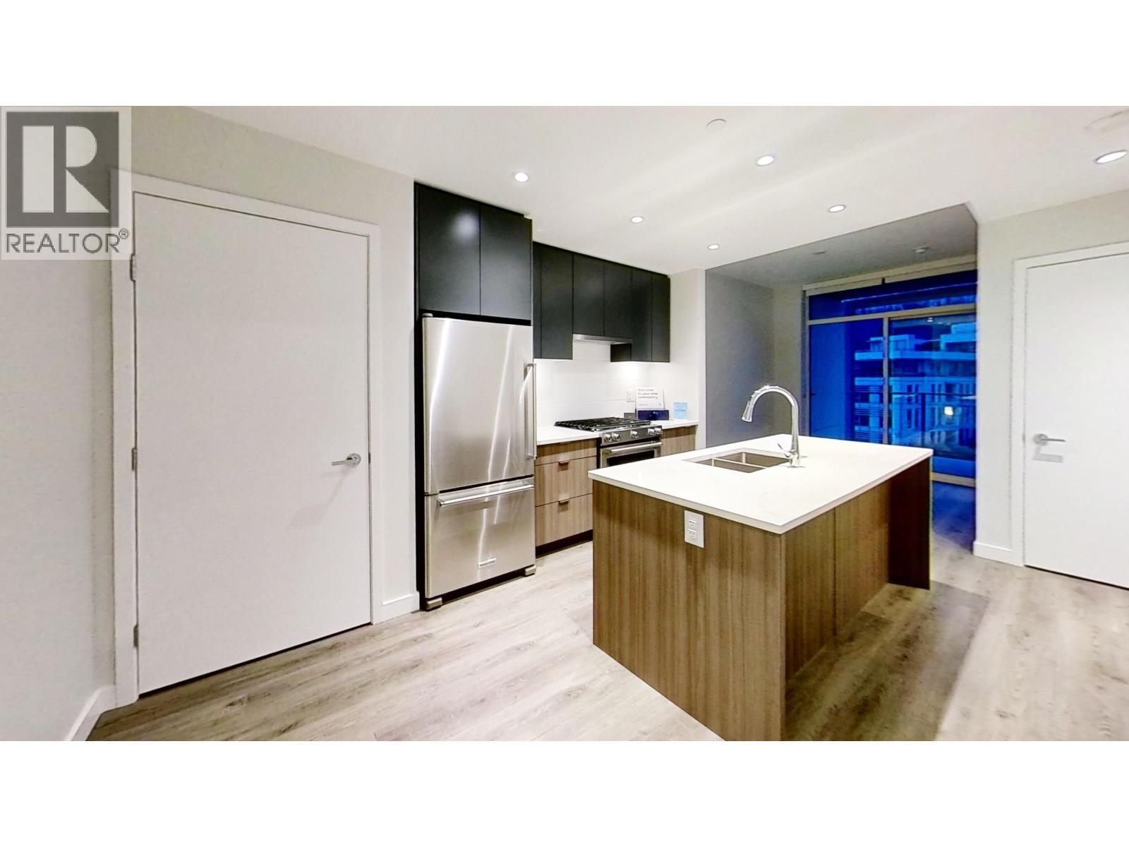 A modern kitchen with a wooden island and stainless steel appliances.