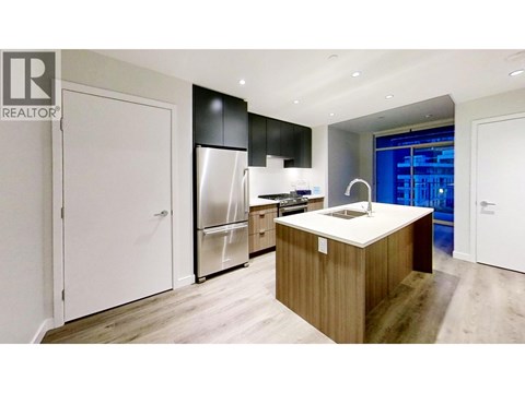 A modern kitchen with a wooden island and stainless steel appliances.