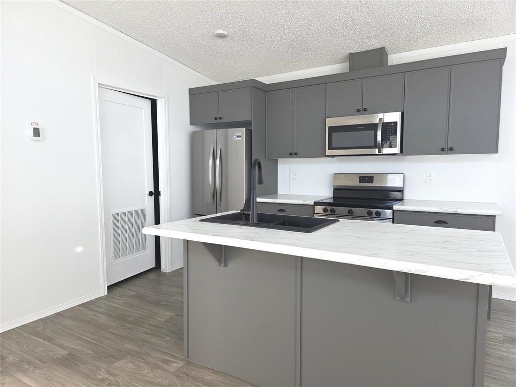 A kitchen with a white countertop and grey cabinets.