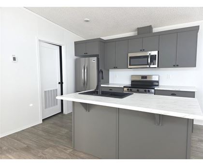 A kitchen with a white countertop and grey cabinets.