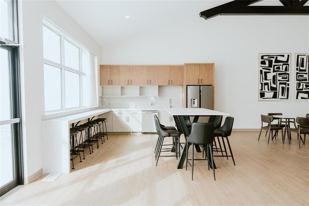 A modern dining room with a white table and black chairs.