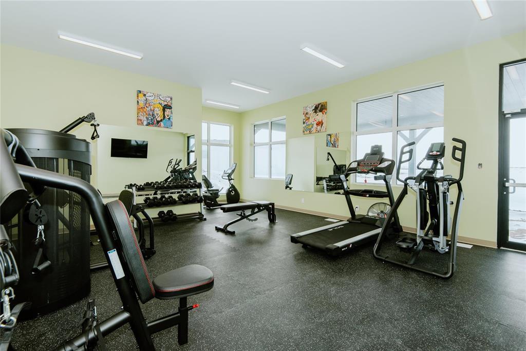 A gym with a variety of equipment including treadmills, weights, and exercise machines.