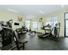 A gym with a variety of equipment including treadmills, weights, and exercise machines.