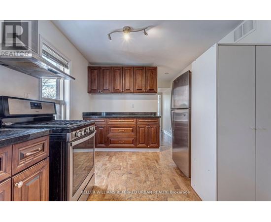 A kitchen with wooden cabinets and a black counter top.