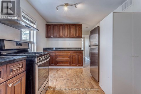 A kitchen with wooden cabinets and a black counter top.