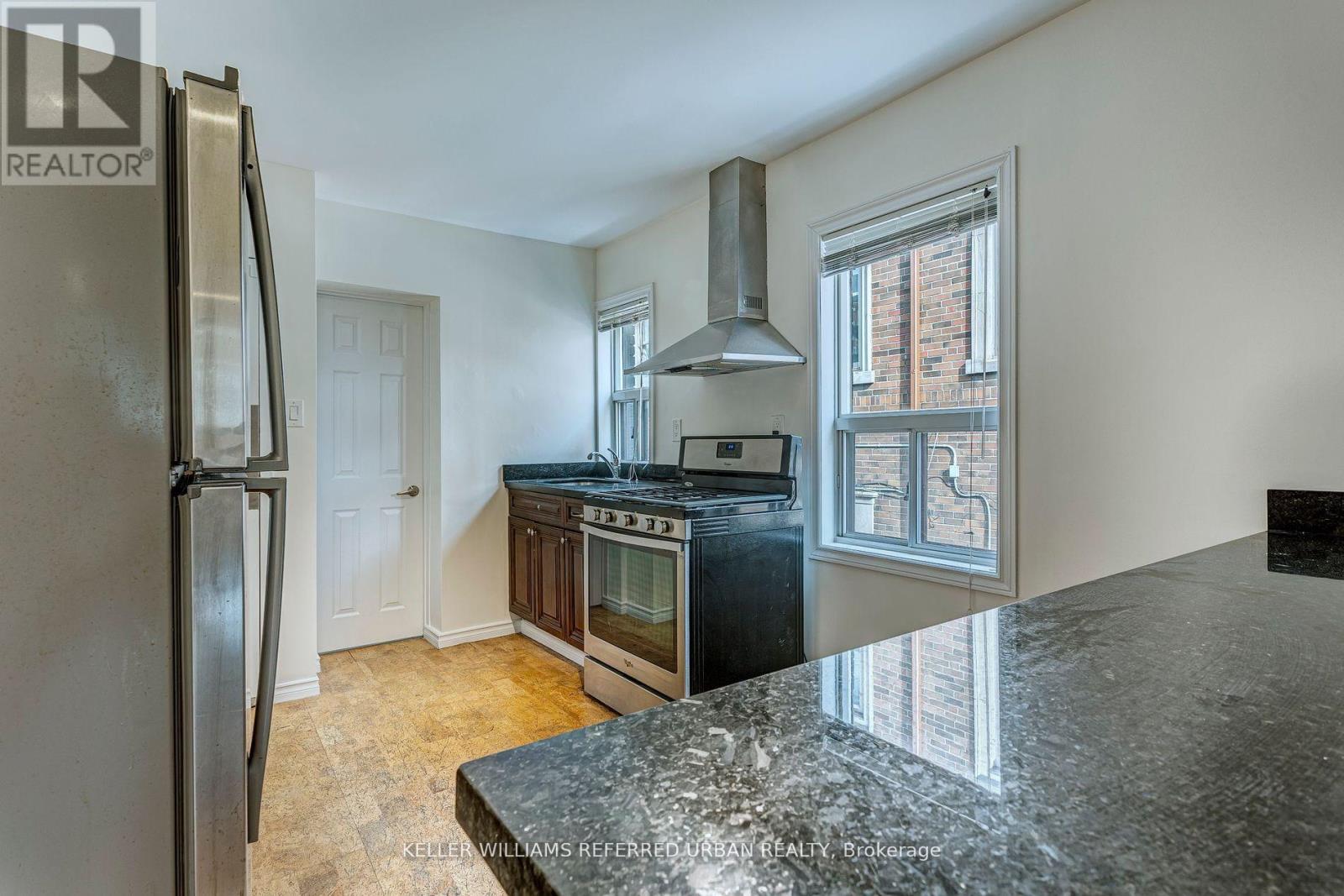 A kitchen with a granite counter top and stainless steel appliances.