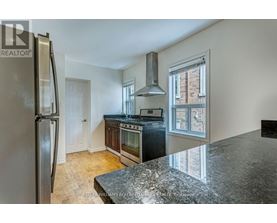 A kitchen with a granite counter top and stainless steel appliances.