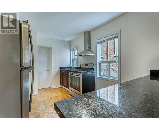 A kitchen with a granite counter top and stainless steel appliances.