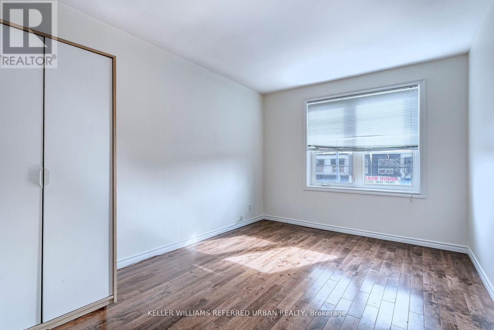 A room with a window and wooden flooring.