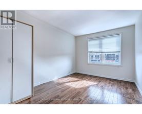A room with a window and wooden flooring.