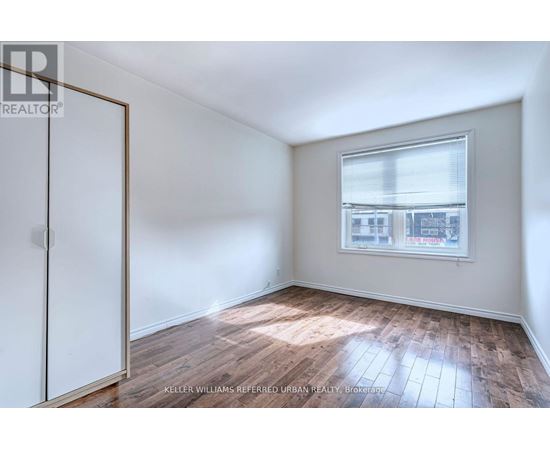 A room with a window and wooden flooring.