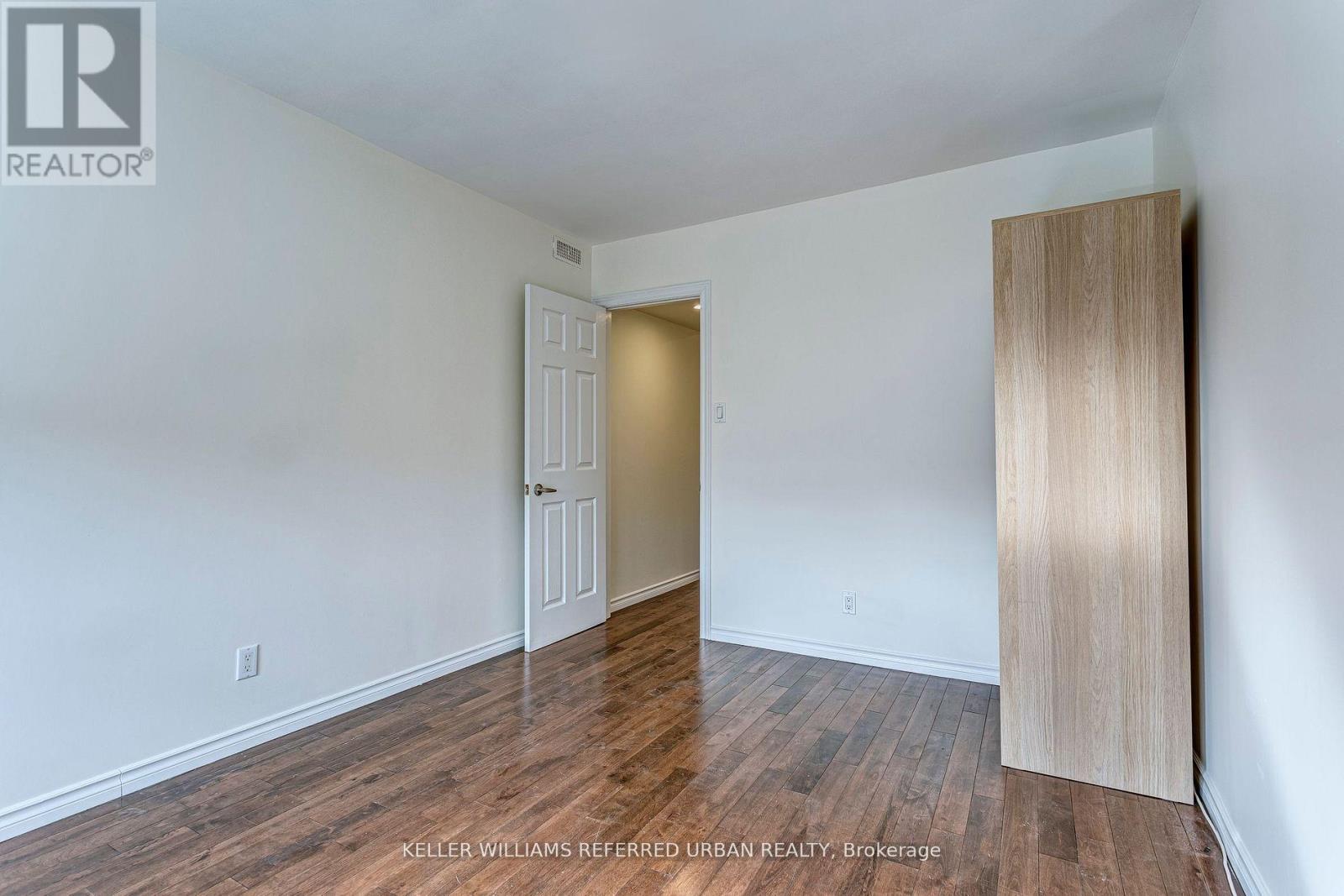 A room with a white door and a wooden door frame.
