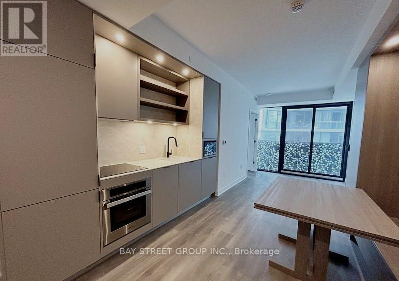 A modern kitchen with a wooden table and stainless steel appliances.