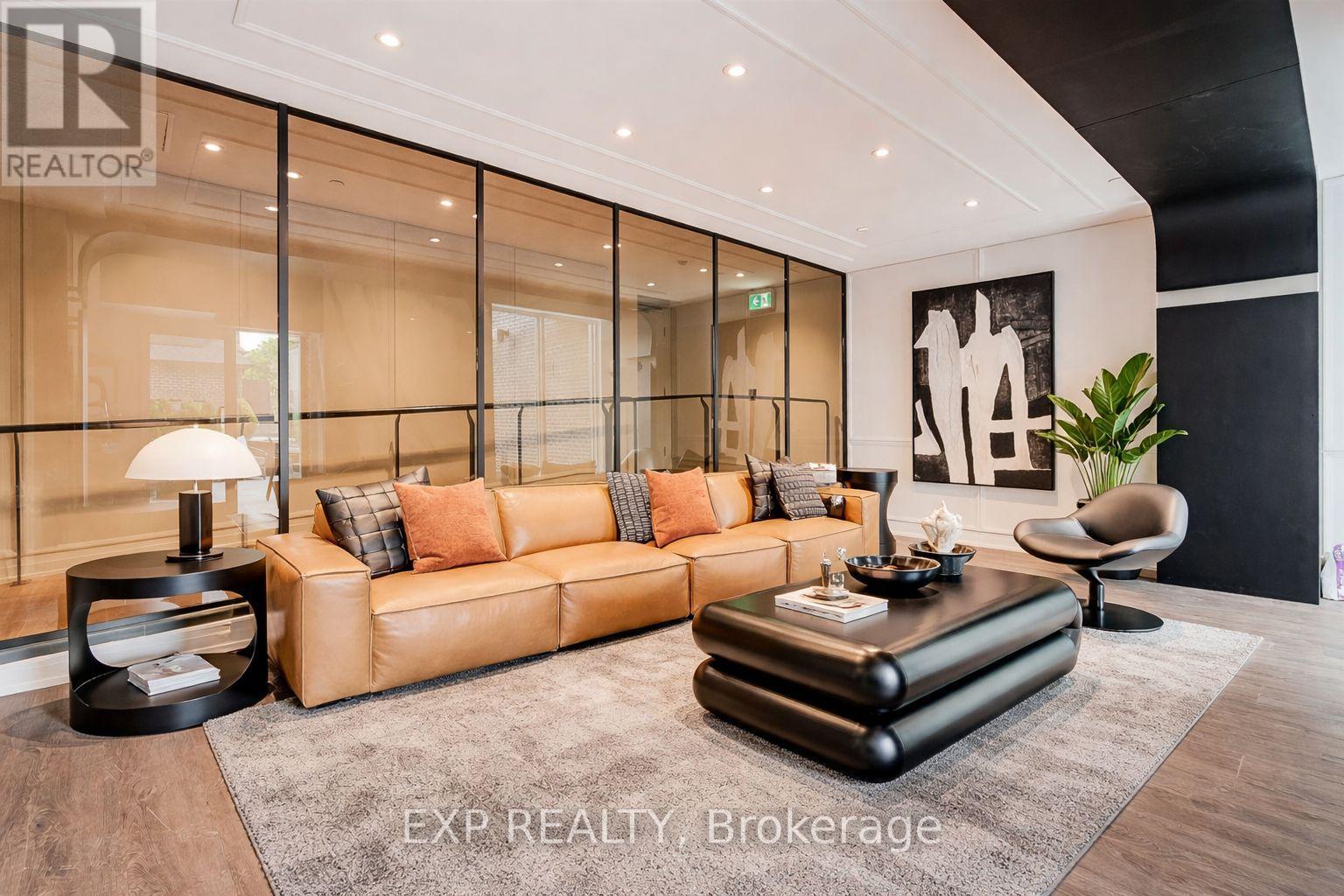 A living room with a tan couch and a black coffee table.