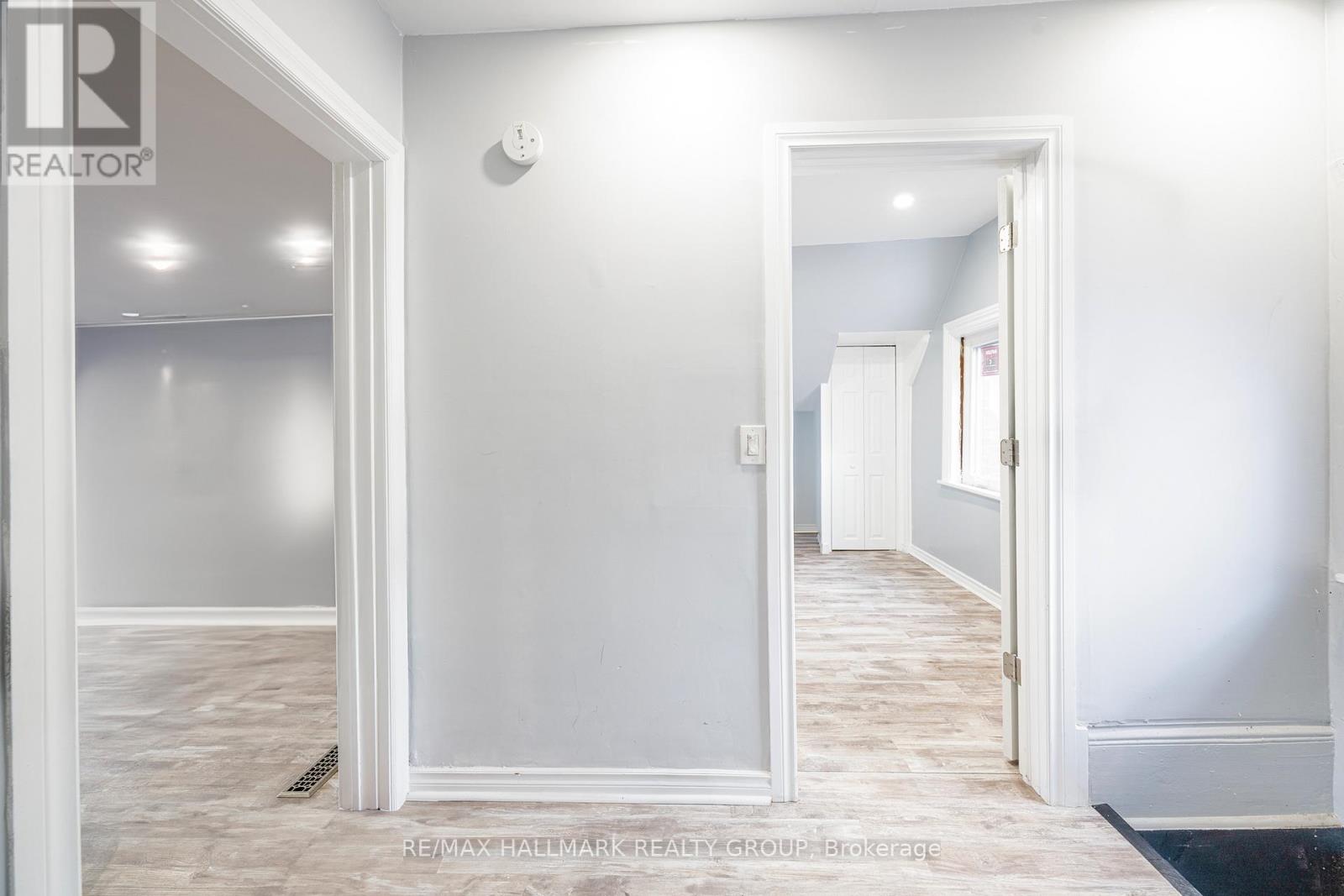 A hallway with white walls and a black doormat.