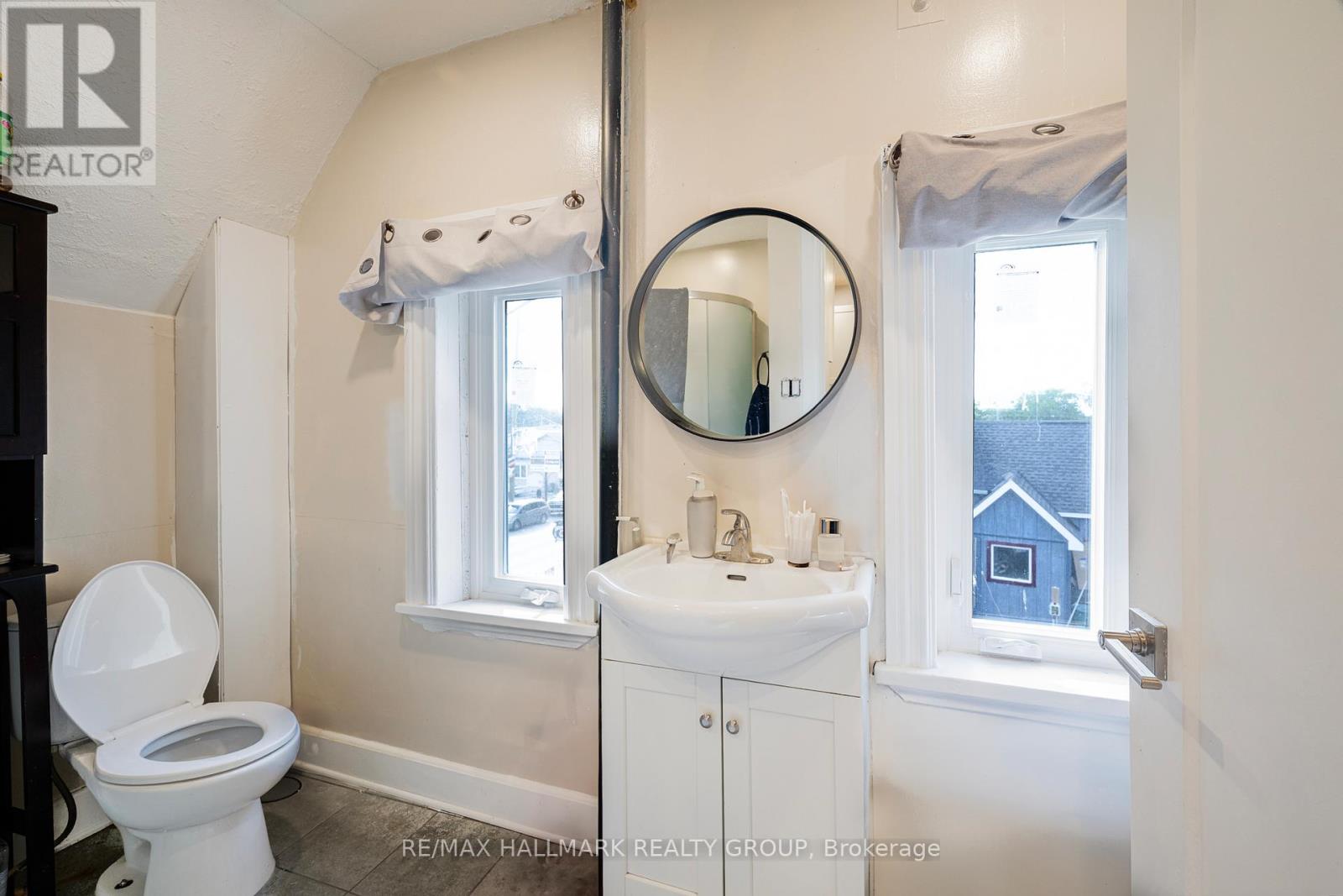 A white toilet sits next to a sink in a small bathroom.