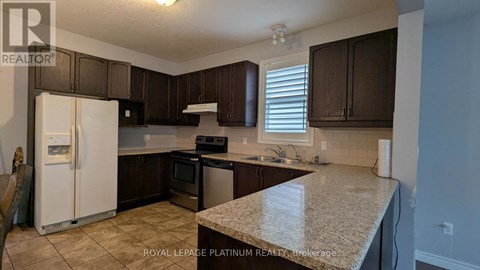 A kitchen with brown cabinets and a white refrigerator.