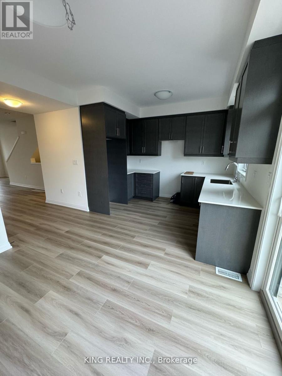 A kitchen area with black cabinets and a white fridge.