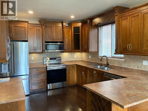 A kitchen with wooden cabinets and a granite countertop.