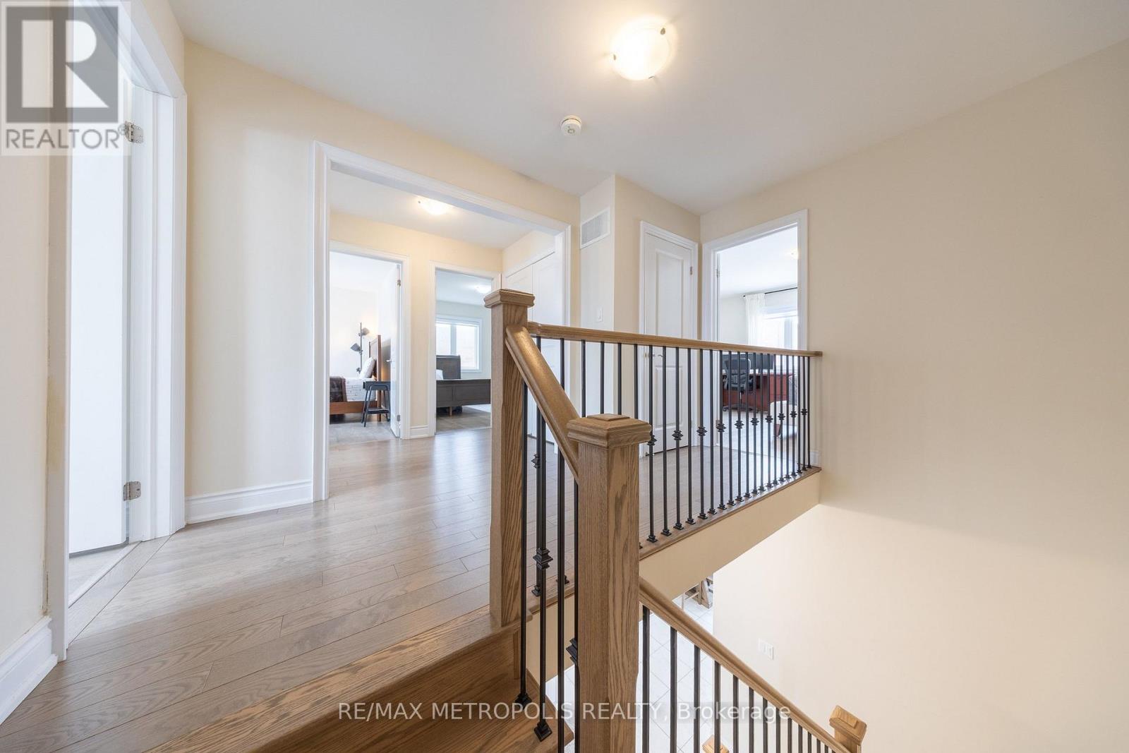 A spacious room with a wooden staircase leading to the second floor.
