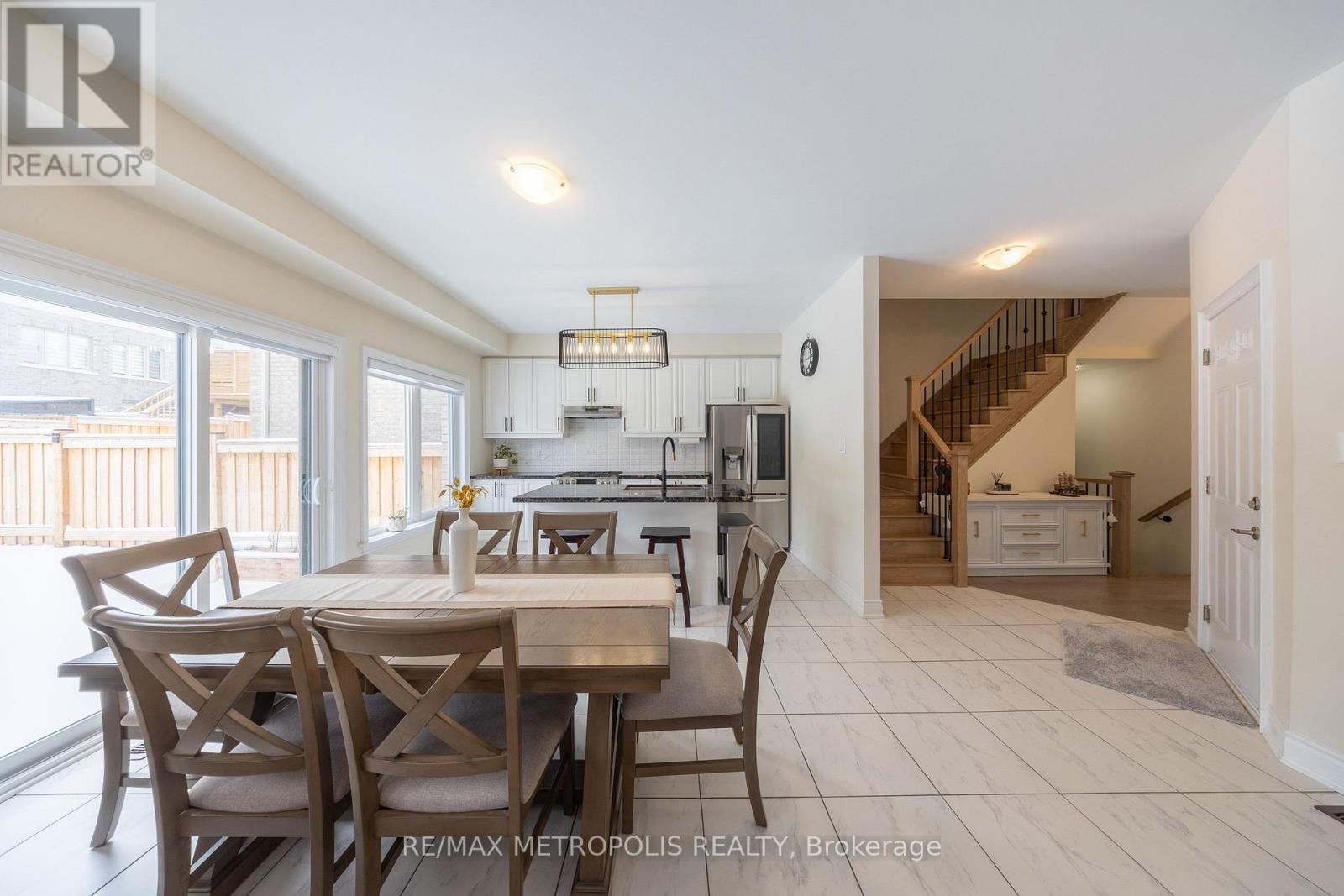 A dining room with a table set for four with a kitchen in the background.