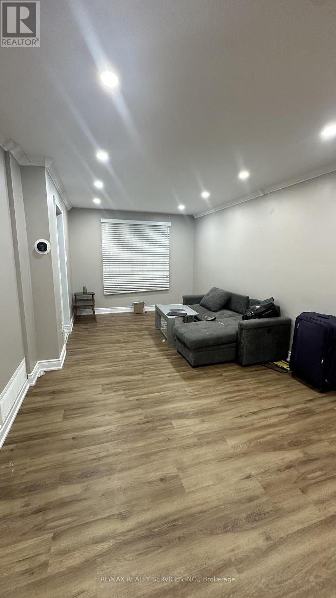 A room with a grey sofa and wooden flooring.