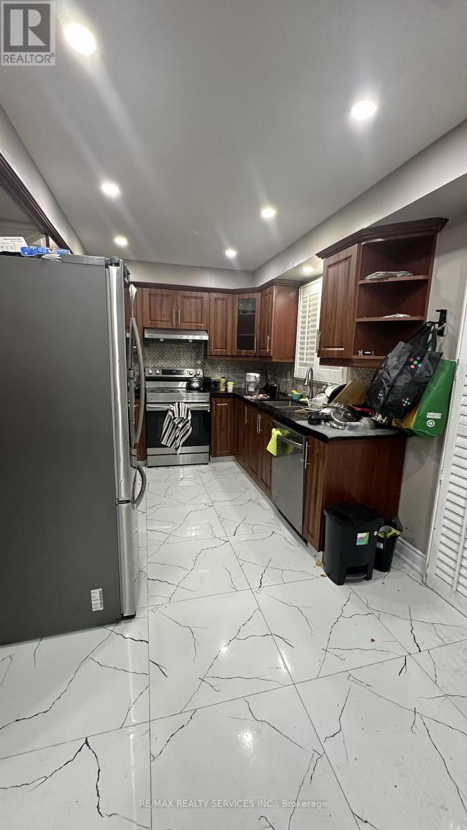 A kitchen with a refrigerator, cabinets, and a counter.