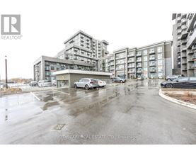 A wet parking lot with cars and apartment buildings in the background.