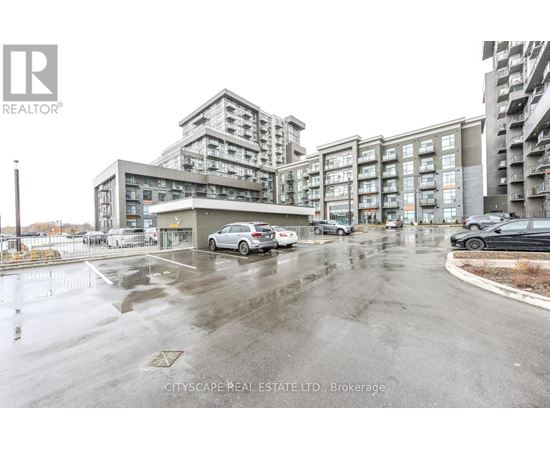 A wet parking lot with cars and apartment buildings in the background.