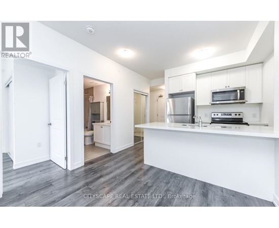 A kitchen with white cabinets and a stainless steel refrigerator.