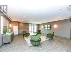 A spacious room with green chairs and a wooden floor.