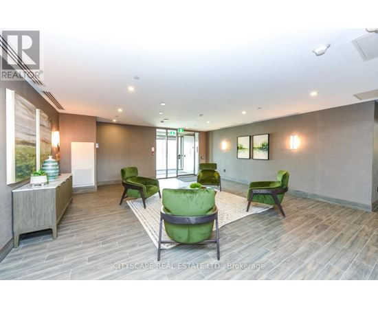 A spacious room with green chairs and a wooden floor.