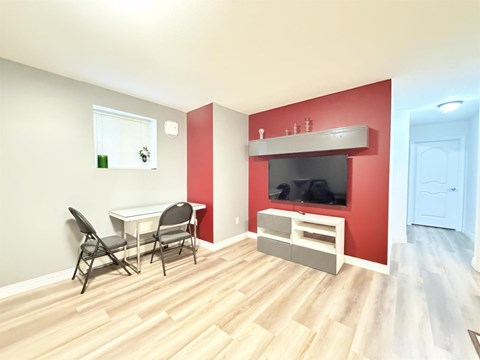 A living room with a television and a dining table.