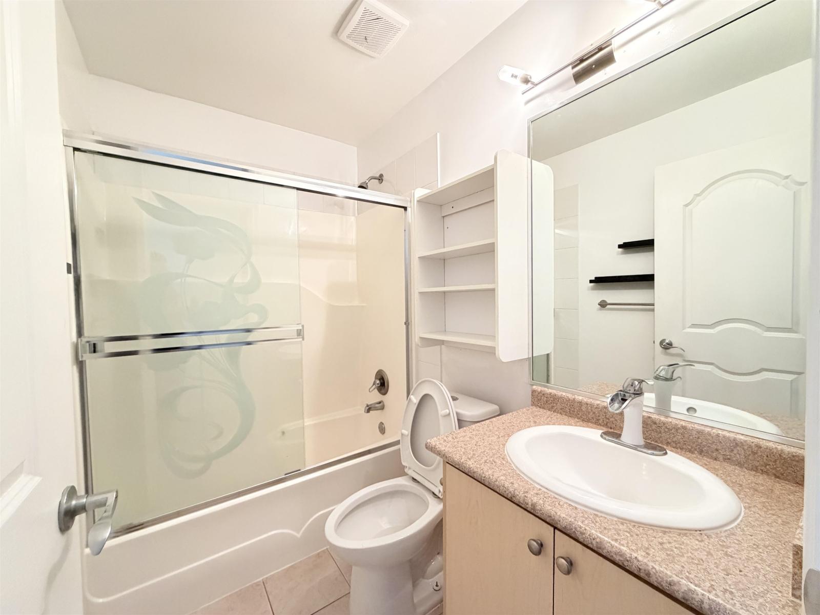A bathroom with a toilet, sink, and shower.
