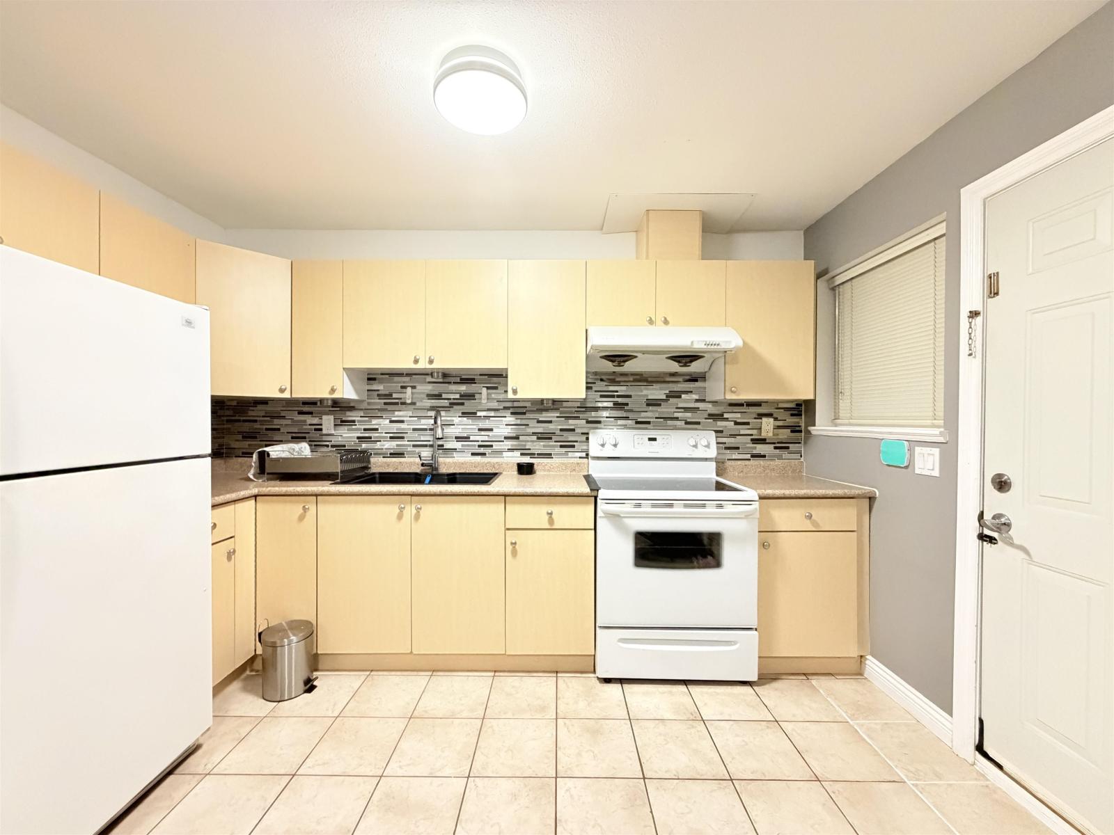 A kitchen with a white refrigerator and a white oven.