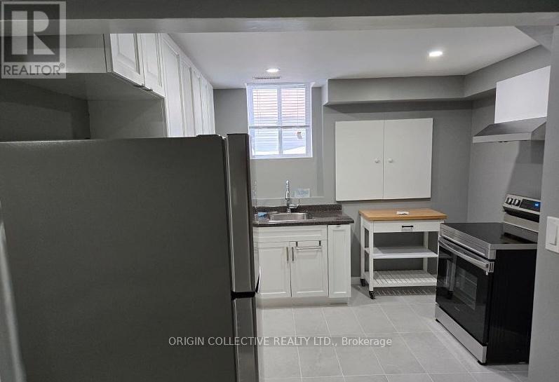 A kitchen with a refrigerator, oven, and cabinets.