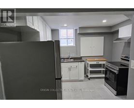 A kitchen with a refrigerator, oven, and cabinets.