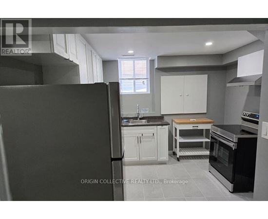 A kitchen with a refrigerator, oven, and cabinets.