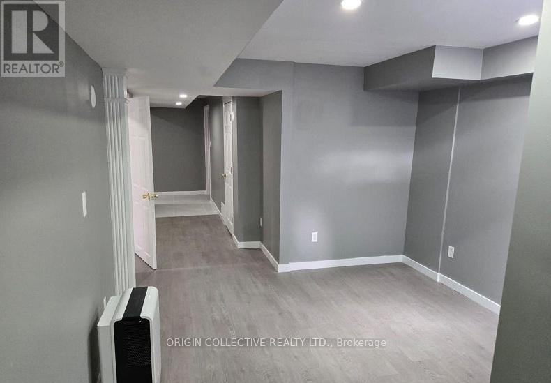 A spacious room with a grey wall and a white door.