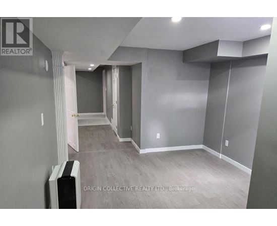 A spacious room with a grey wall and a white door.