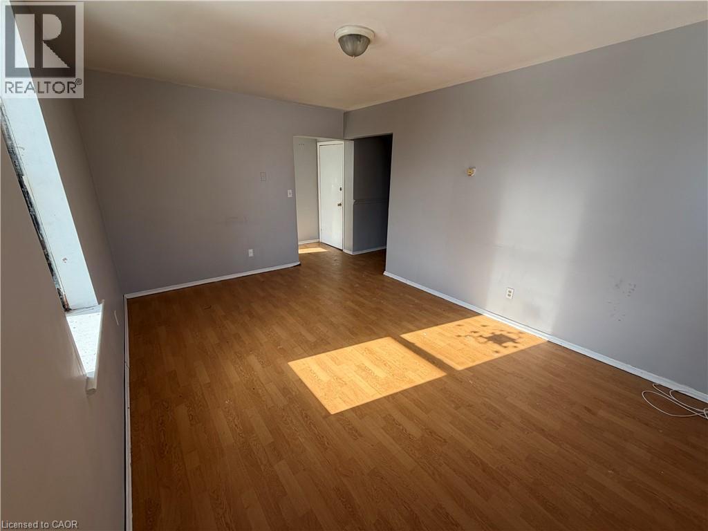 A room with wooden flooring and a door on the right side.