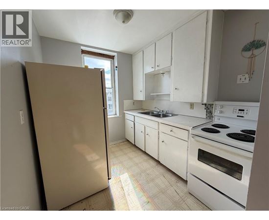A kitchen with white cabinets and appliances is shown.