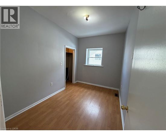 A room with wooden flooring and a window.