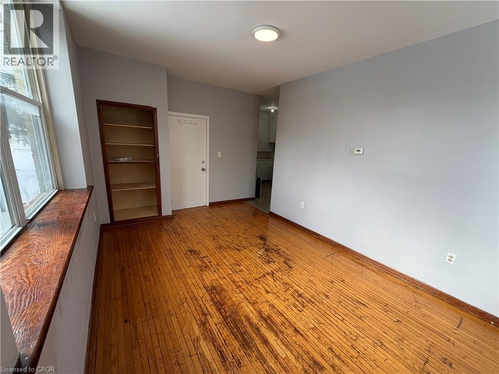 A room with wooden flooring and white walls.