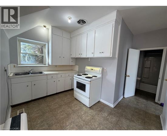 A kitchen with white cabinets and a stove top oven.