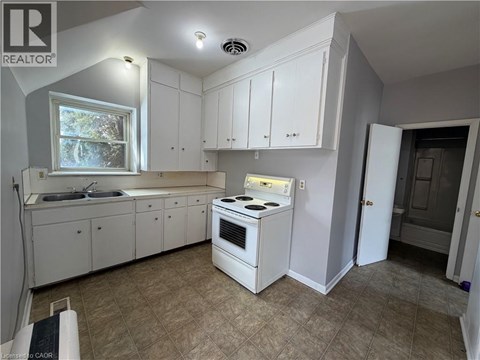 A kitchen with white cabinets and a stove top oven.
