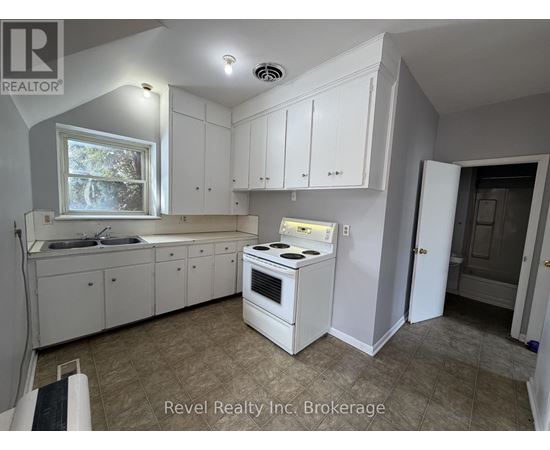 A kitchen with white cabinets and a stove top oven.